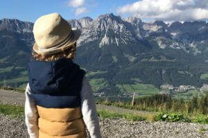 Kind vor dem Bergpanorama bei Seefeld auf dem Rosskopf-Abenteuerspielplatz in Tirol in Österreich.